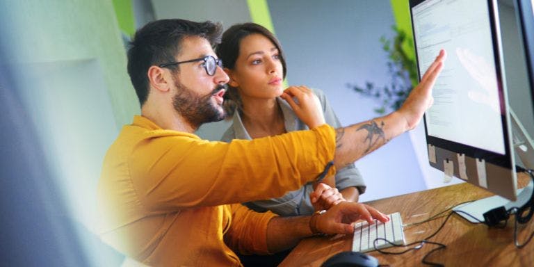 Two colleagues choosing between different types of HR software