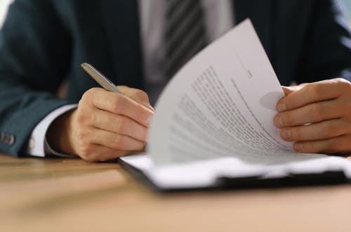 A male employee is ready and signing legal documentation.