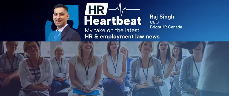 Group of smiling employees being addressed by a speaker