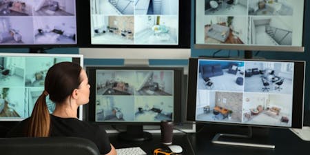 Excessive employee monitoring A woman sat at a desk viewing multiple screens of live surveillance footage