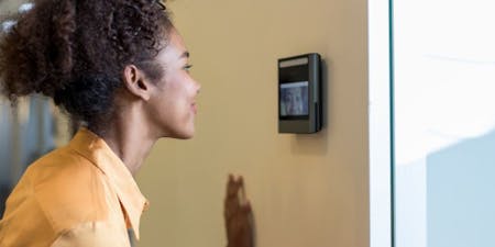 A woman using facial recognition system to clock into her job