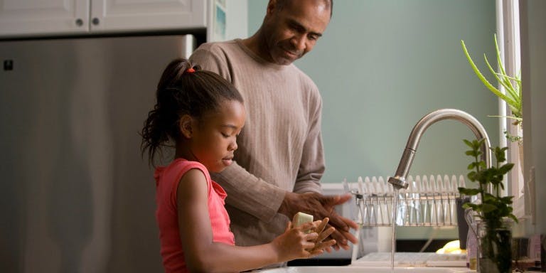 Father and daughter at kitchen sink
