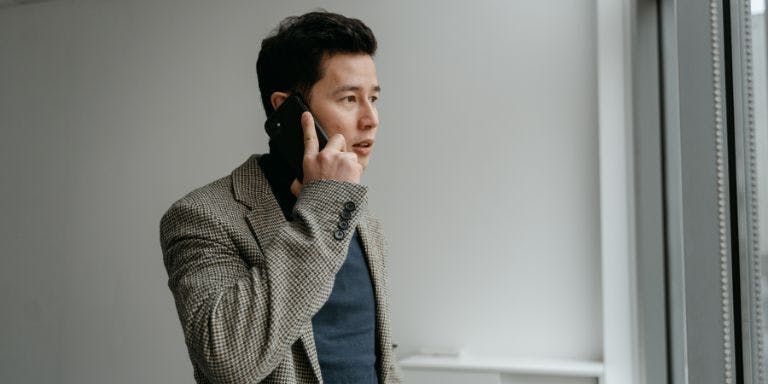 Contacting staff on sick leave Employer in a room on the phone to an employee on sick leave