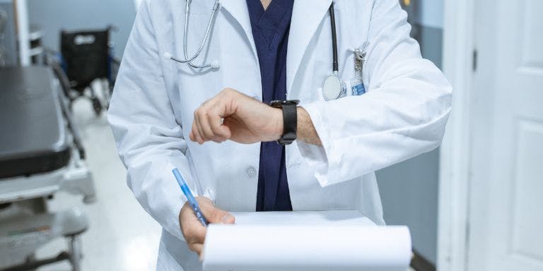 Time management for the healthcare industry A healthcare professional checking his watch