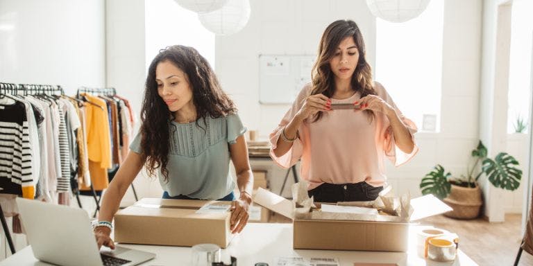 Two small business owners packing stock to be delivered to customers