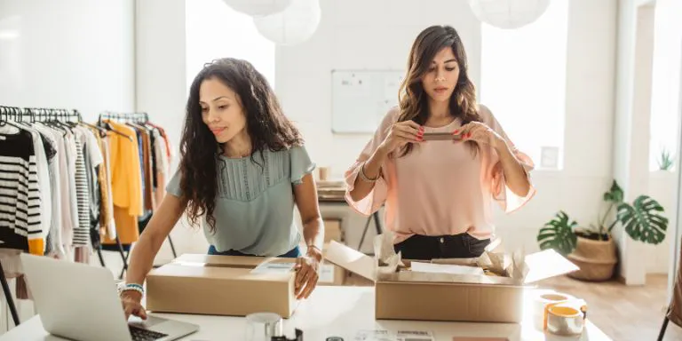 Two small business owners packing stock to be delivered to customers