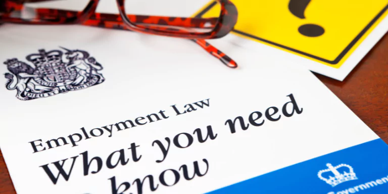 A document on a table titled "Employment Law | What you need to know"
