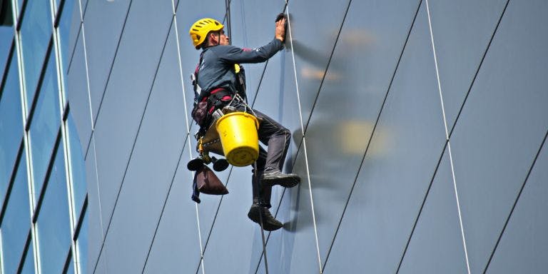 A window cleaner scaling the exterior of a skyscraper
