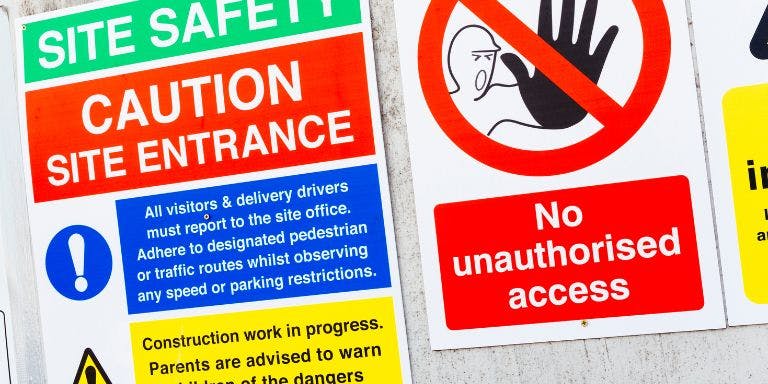 Safety signs in the workplace Several safety signs used at the entrance of a construction site