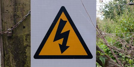 A hazard warning sign A hazard warning sign warning pedestrians of overhead electrical lines