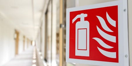 Fire safety signs in the workplace A fire safety sign showing the location of a fire extinguisher in red and white