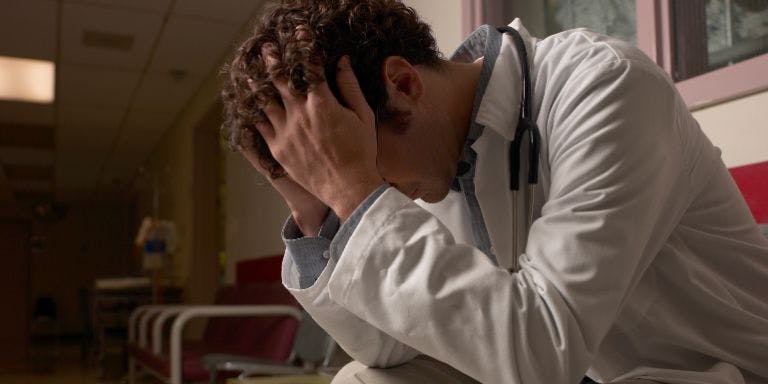 Night shift worker wellbeing Night shift doctor feeling stressed and overwhelmed on shift