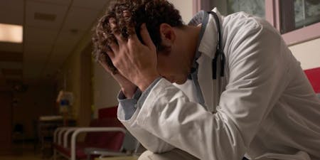 Night shift worker wellbeing Night shift doctor feeling stressed and overwhelmed on shift