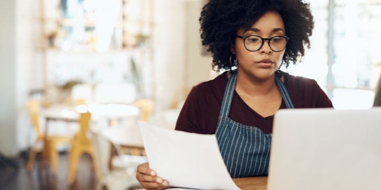 A small business owner reviewing payroll documentation