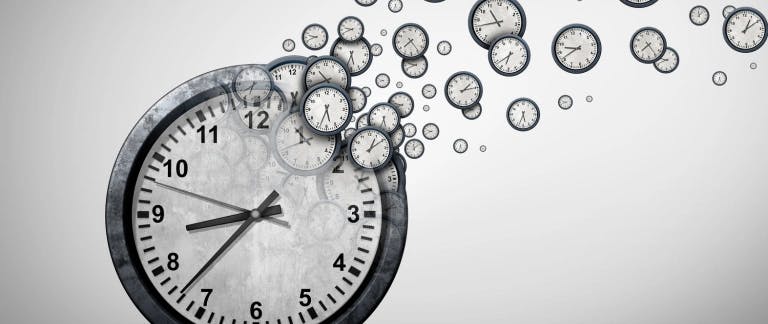 An image of a large clock with smaller clocks flying away from it