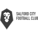 A black and white logo with a lion's head in a shield shape. The lion's head is white and the shield is gray. The lion's face is facing the viewer, and the shield is outlined in white. The logo is set against a black background.
