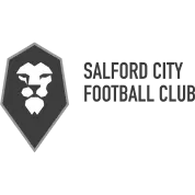 A black and white logo with a lion's head in a shield shape. The lion's head is white and the shield is gray. The lion's face is facing the viewer, and the shield is outlined in white. The logo is set against a black background.