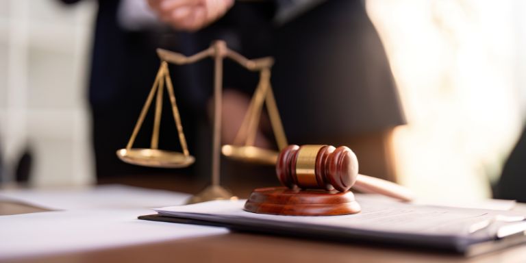 A judge's gavel and scales on a table