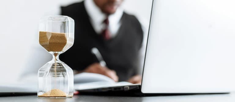 Record of Employment An employer issuing a record of employment, with a sand timer in front of his laptop