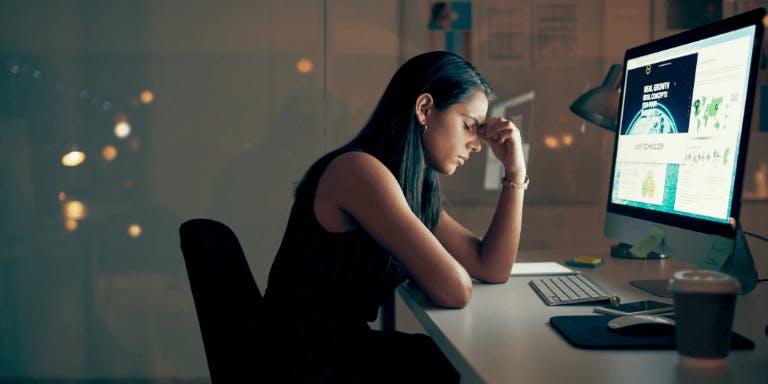 A woman, stressed and burned out at work