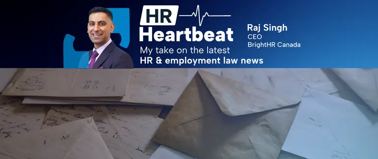 A man in a suit is standing in front of a pile of envelopes.