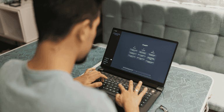 Using ai in the workplace A man using an ai tool to complete a work task on a laptop