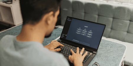 Using ai in the workplace A man using an ai tool to complete a work task on a laptop