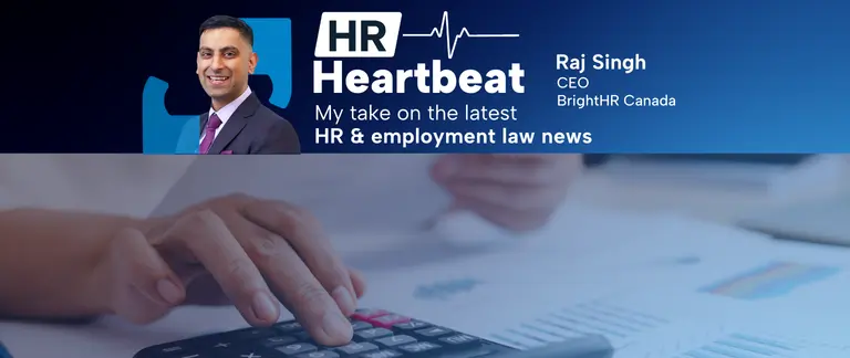 an image of a hand typing on a calculator, holding a document in their other hand.