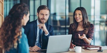 Shortlisting applicants with the support of AI An group of managers discussing the shortlisting of job applicants at a table with a laptop and notebooks