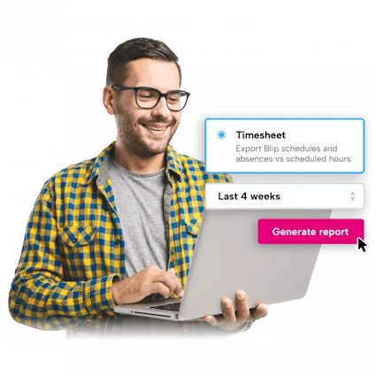 A man wearing glasses is smiling while using a laptop computer.