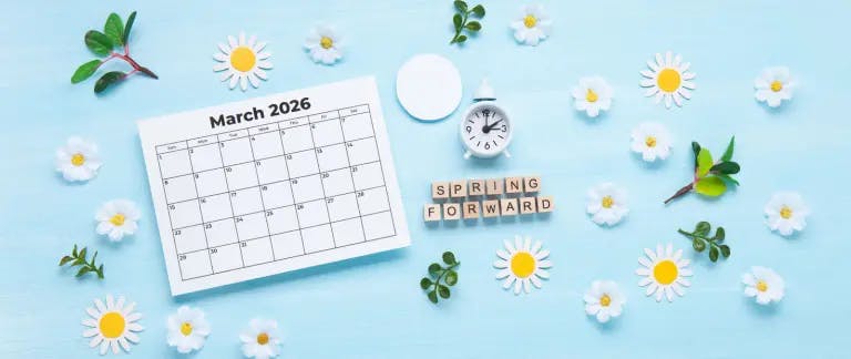 A calendar with the word "Spring" written on it, a clock, a map, and daisies are arranged on a blue background.