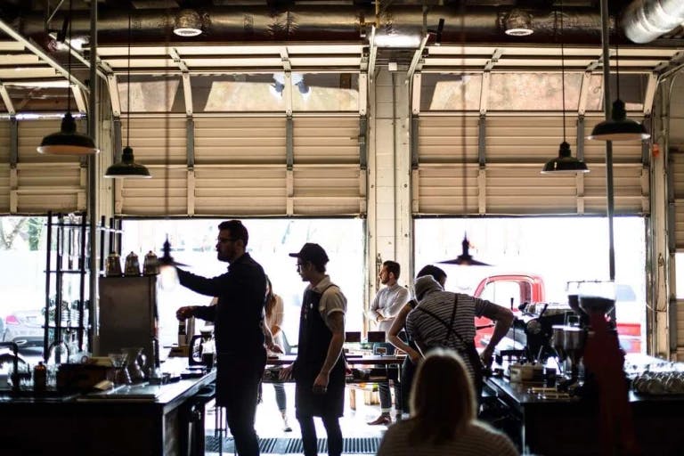 A bustling restaurant scene with patrons and staff.