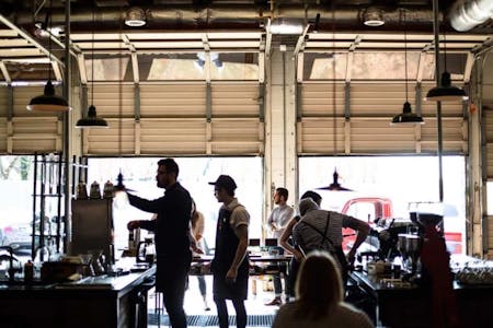 A bustling restaurant scene with patrons and staff.