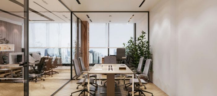 The image showcases an office space with a modern design. The room is enclosed by glass walls, allowing a view of the city skyline outside. The floor is made of light-colored tiles, and the walls are painted white. The room is furnished with wooden chairs and a wooden table. A potted plant is placed on the table, adding a touch of greenery to the space.