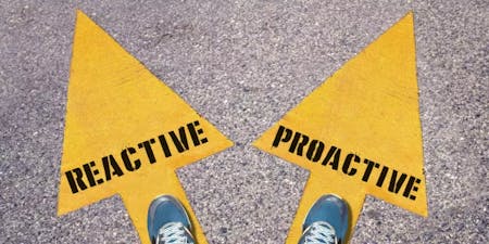 Proactive vs reactive health and safety management A person standing on two yellow arrows. One has the word Reactive painted on it while the other says Proactive