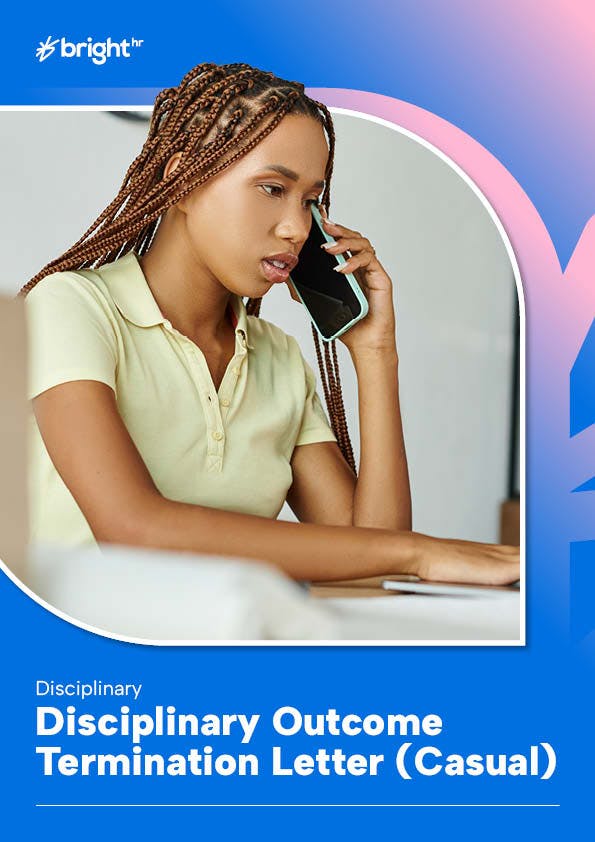 A young woman with braided hair is seated at a desk, engrossed in a phone call. She is wearing a light-colored polo shirt and is holding a phone to her ear.