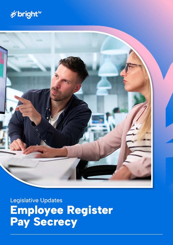 The image features a man and a woman in an office setting. The man is pointing at a computer screen, suggesting some sort of interaction or discussion.