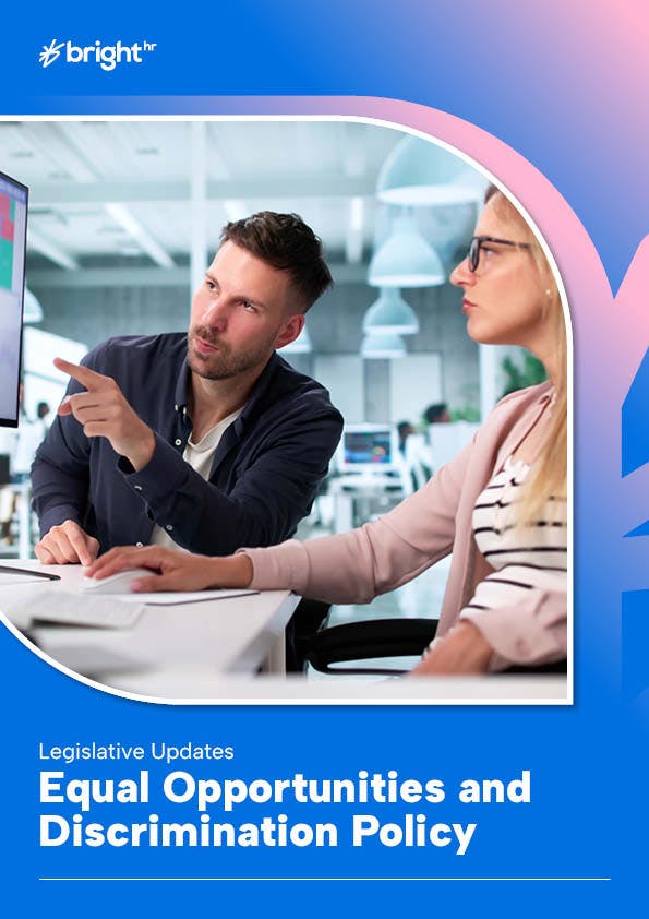 The image features a man and a woman in an office setting. The man is pointing at a computer screen, suggesting some form of instruction or guidance.