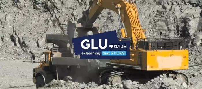 Excavator loading materials onto back of truck on jobsite