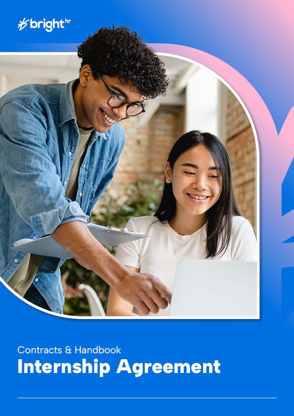 Two employees having a conversation and looking at a laptop