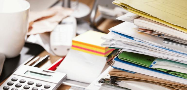 Spring Clean Your HR Systems Messy desk covered in paperwork