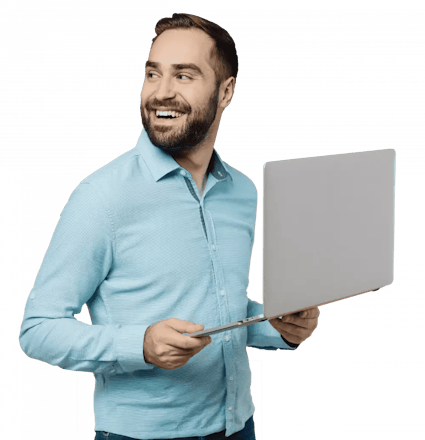 A person smiling holding a laptop.
