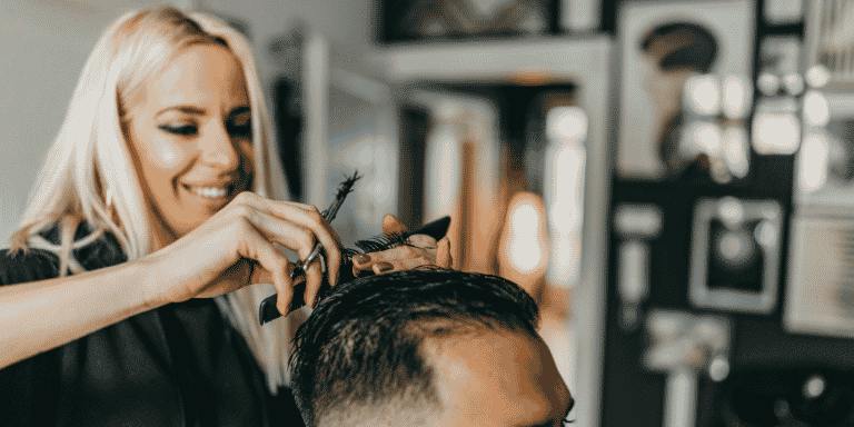 A hair salon owner cutting a customer's hair