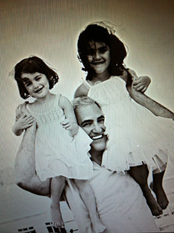 Dr. Alizadeh holding two happy girls on his shoulders.