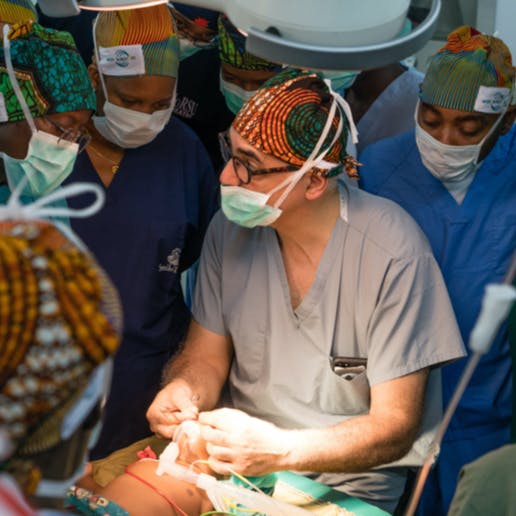 Dr. Alizadeh operating on a young child with doctors watching.