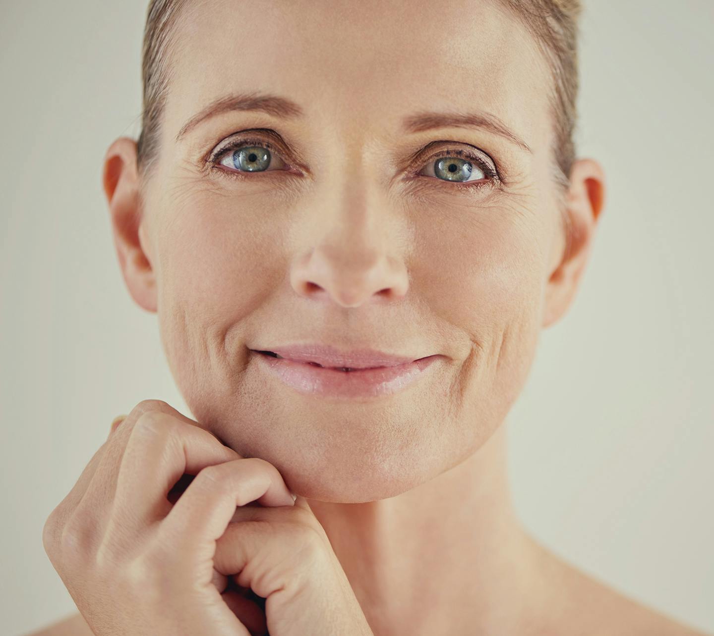 Woman smiling with her hands under her chin.
