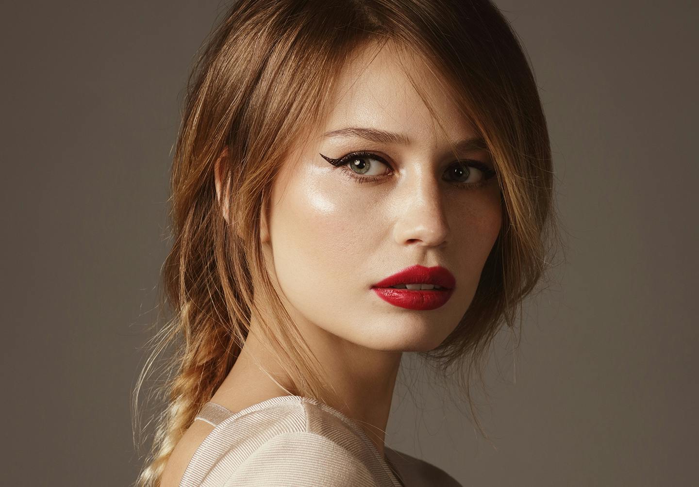 Woman with red lipstick posing looking over her shoulder.