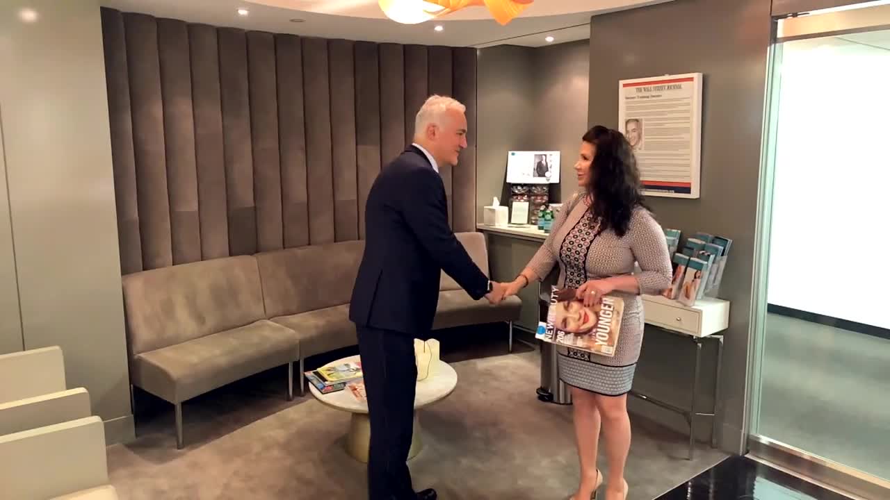 Dr. Alizadeh greeting a woman in his office.