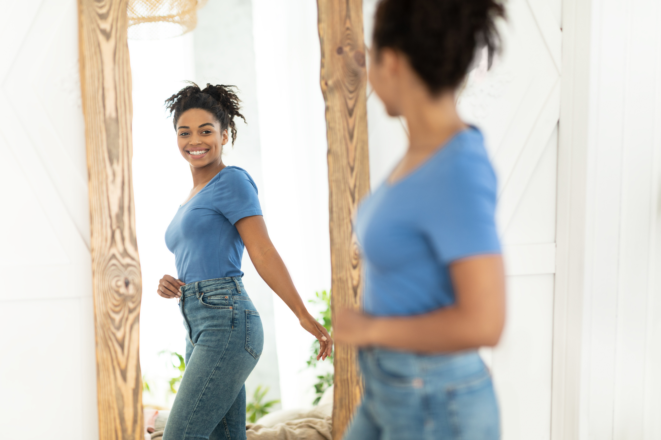 Happy woman looking at herself in the mirror.