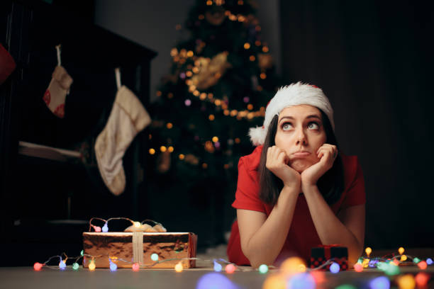 Bored woman with Christmas tree in background.